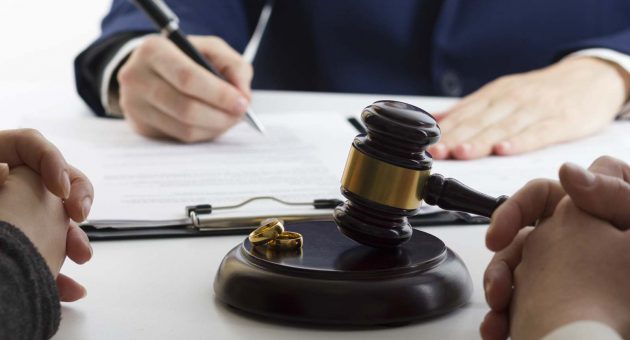 A judge's gavel rests beside a wedding ring, symbolizing the legal proceedings of divorce.