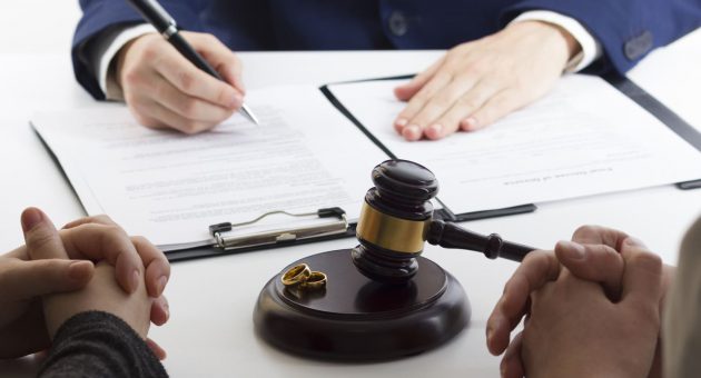 A wedding ring lies next to a judge's gavel, representing the intersection of love and legal dissolution in divorce.