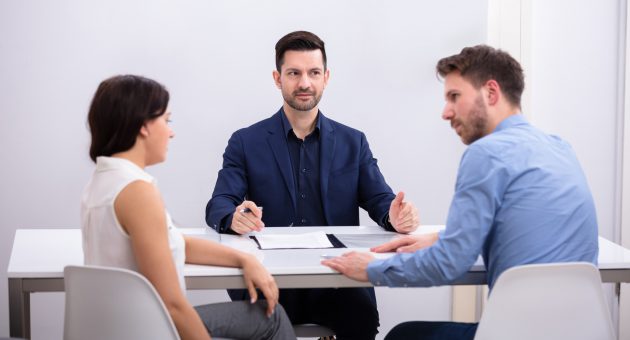 Rear View Of A Couple Sitting In Front Of Judge