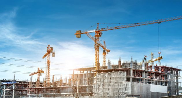 A bustling construction site featuring cranes and various construction equipment actively engaged in building activities.