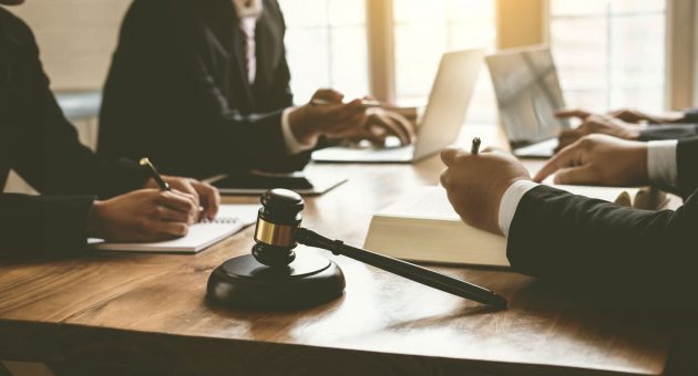 A group of lawyers and judges engaged in a formal meeting, discussing legal matters and case strategies.